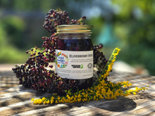 Load image into Gallery viewer, Elderberry Syrup jar with fresh elderberries and goldenrod