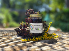 Load image into Gallery viewer, Elderberry Syrup jar outdoors with elderberries and goldenrod
