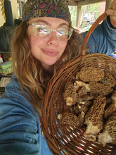 Load image into Gallery viewer, Elise Dixie Jane holding a basket of foraged mushrooms at Wild Indigo Forest Farm