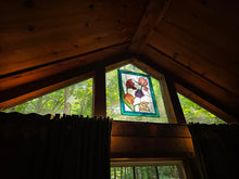 Load image into Gallery viewer, Stained-glass window and warm wood interior of Hummingbird Haven at Wild Indigo Forest Farm