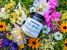 Load image into Gallery viewer, Lunar Phase botanical soy candle surrounded by farm flowers