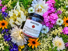 Load image into Gallery viewer, Rooted botanical soy candle surrounded by farm flowers
